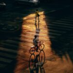 girl in white shirt and pants riding bicycle on road during night time