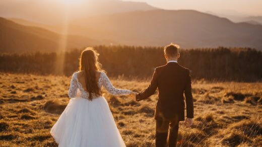 man and woman in wedding dress walking on brown grass field during daytime