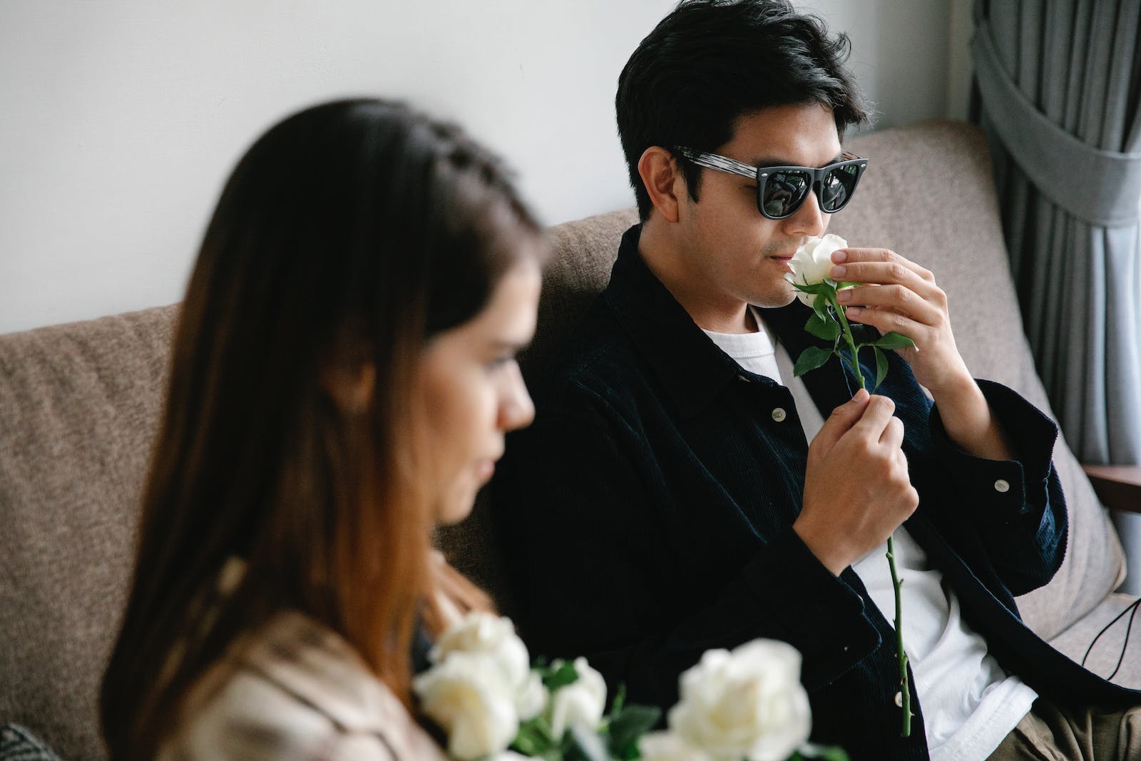 Photo of Man Smelling White Rose