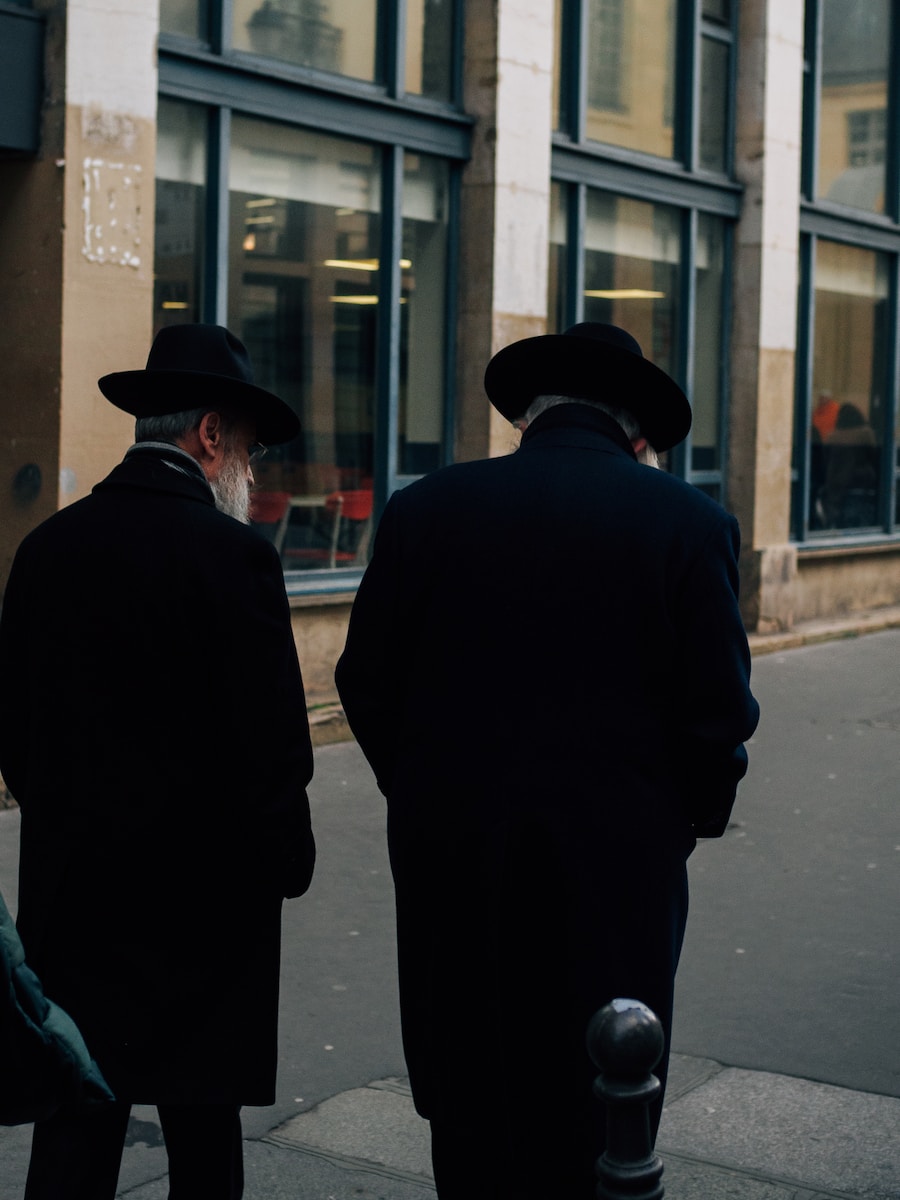 two men standing on a sidewalk in front of a building