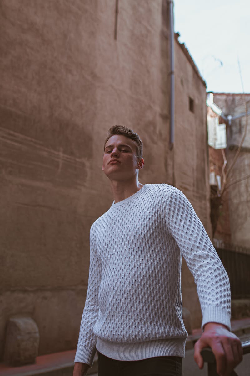 Confident young man standing on old town street